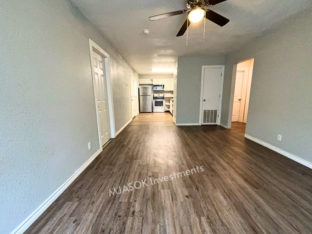 Open living area with vinyl plank flooring and ceiling fan